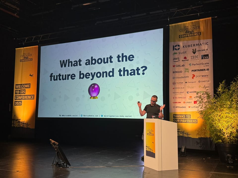 A photo of Marcus giving a talk at ContainerDays. The large screen at the back has a slide that says "What about the future beyond that?"