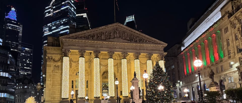 A nighttime photo of London buildings lit up with Christmas lights.